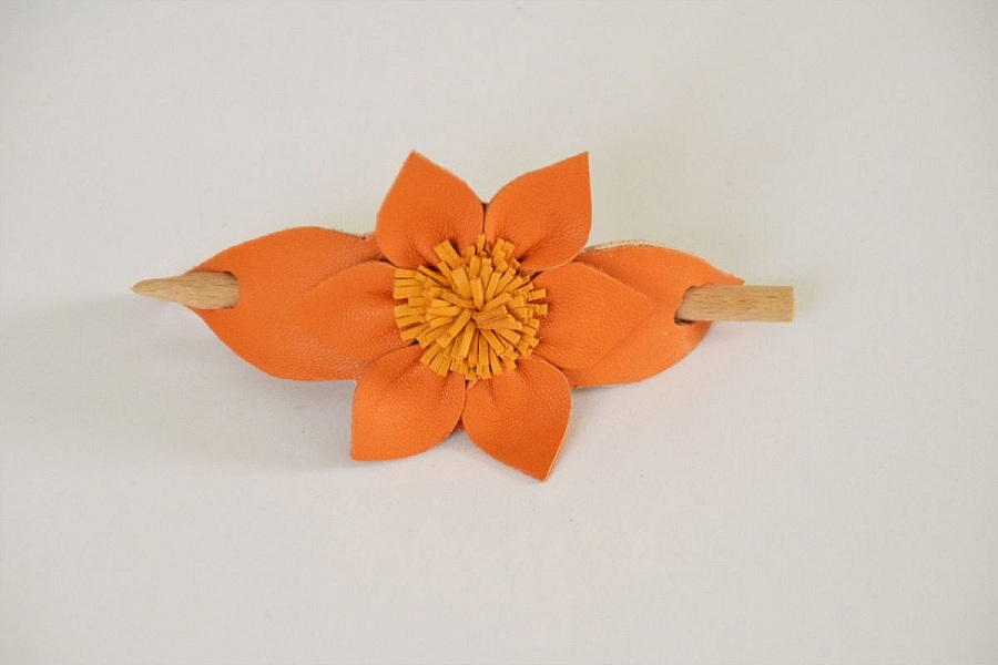 Barrette fleur en cuir orange avec pique en bois.