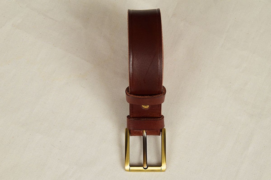 Ceinture artisanale en cuir végétal marron avec boucle métallique.